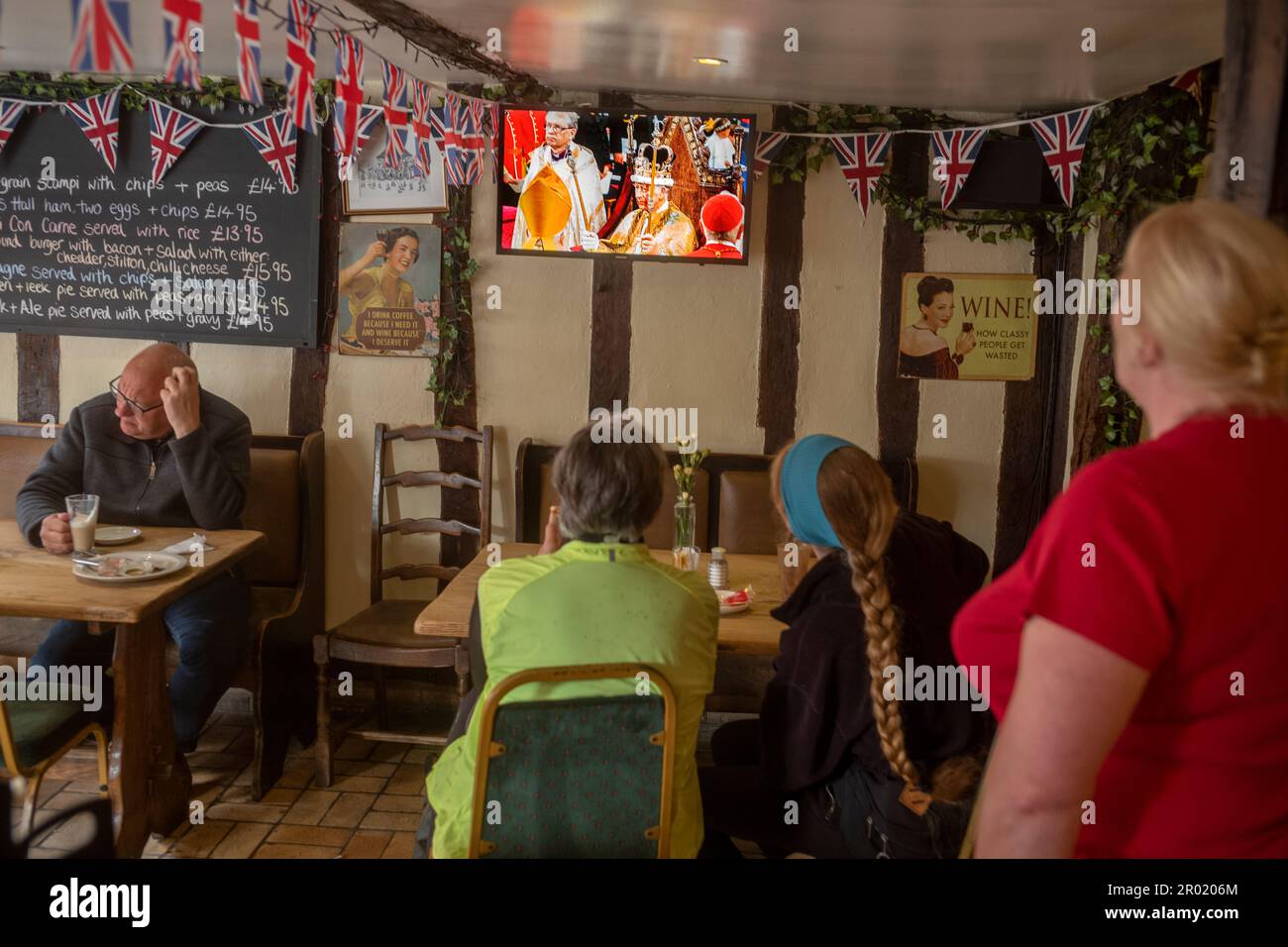 Thaxted, Inghilterra Regno Unito GB. 06th maggio, 2023. Incoronazione Re Carlo III Thaxted Essex UK 6 Maggio 2023 l'incoronazione di Re Carlo III e Regina Camilla all'Abbazia di Westminster a Londra, come visto in televisione al Parrishes Wine Bar di Thaxted nel Nord Essex, Inghilterra. Fotografia di credito: BRIAN HARRIS/Alamy Live News Foto Stock