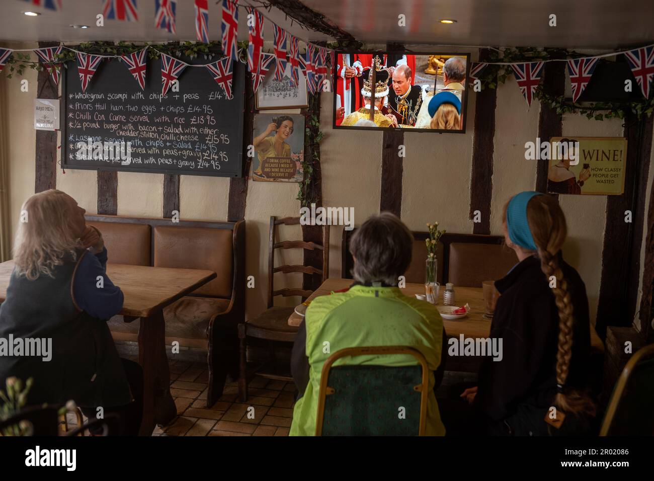Thaxted, Inghilterra Regno Unito GB. 06th maggio, 2023. Incoronazione Re Carlo III Thaxted Essex UK 6 Maggio 2023 l'incoronazione di Re Carlo III e Regina Camilla all'Abbazia di Westminster a Londra, come visto in televisione al Parrishes Wine Bar di Thaxted nel Nord Essex, Inghilterra. Fotografia di credito: BRIAN HARRIS/Alamy Live News Foto Stock