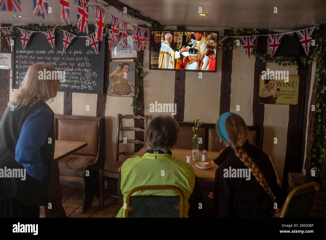 Thaxted, Inghilterra Regno Unito GB. 06th maggio, 2023. Incoronazione Re Carlo III Thaxted Essex UK 6 Maggio 2023 l'incoronazione di Re Carlo III e Regina Camilla all'Abbazia di Westminster a Londra, come visto in televisione al Parrishes Wine Bar di Thaxted nel Nord Essex, Inghilterra. Fotografia di credito: BRIAN HARRIS/Alamy Live News Foto Stock