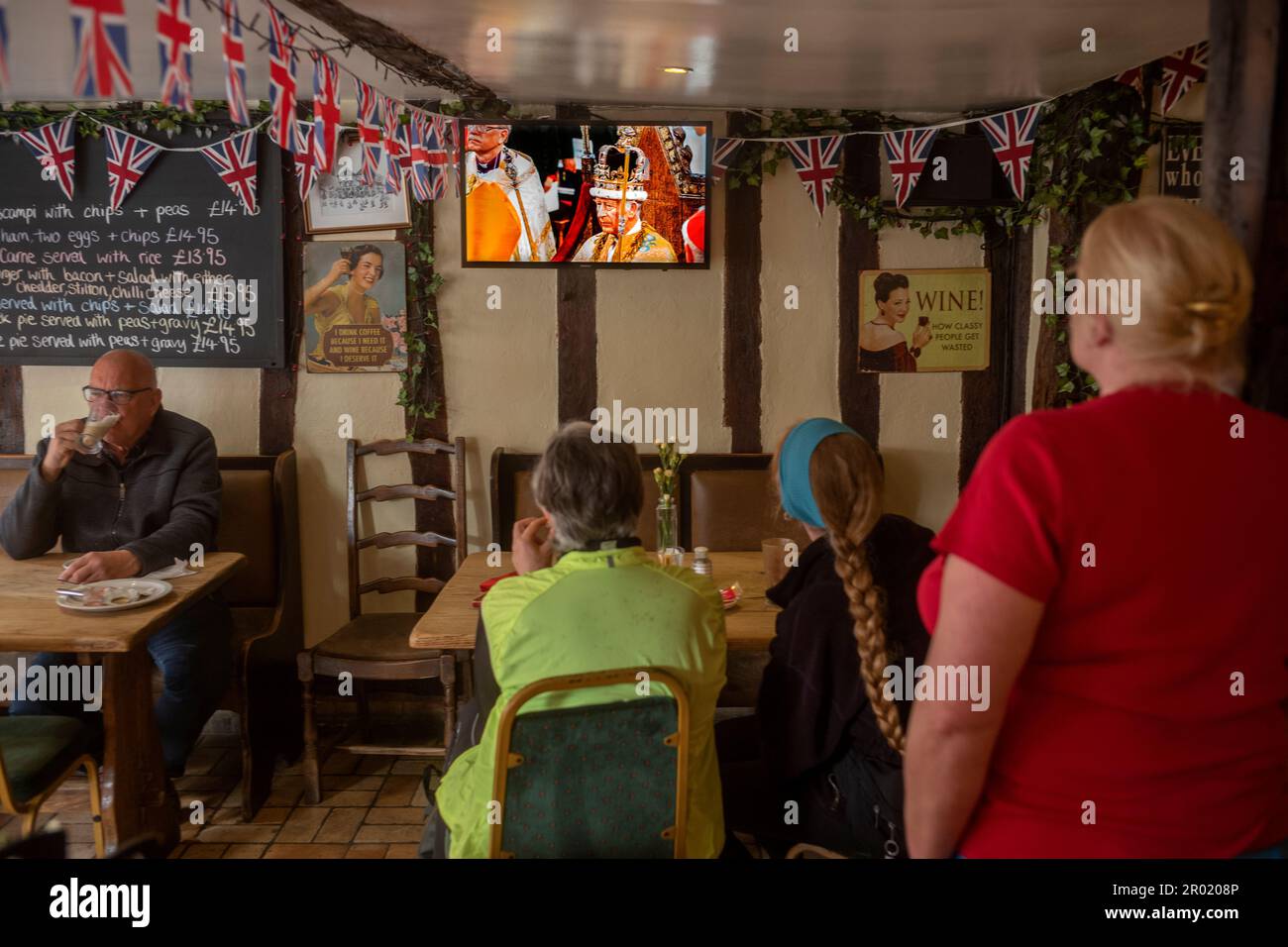 Thaxted, Inghilterra Regno Unito GB. 06th maggio, 2023. Incoronazione Re Carlo III Thaxted Essex UK 6 Maggio 2023 l'incoronazione di Re Carlo III e Regina Camilla all'Abbazia di Westminster a Londra, come visto in televisione al Parrishes Wine Bar di Thaxted nel Nord Essex, Inghilterra. Fotografia di credito: BRIAN HARRIS/Alamy Live News Foto Stock