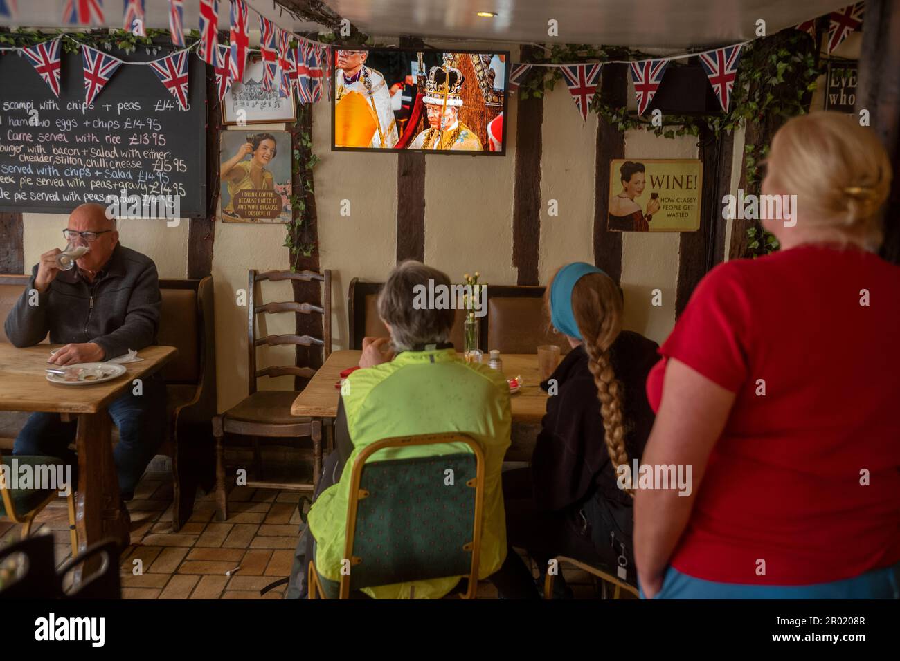 Thaxted, Inghilterra Regno Unito GB. 06th maggio, 2023. Incoronazione Re Carlo III Thaxted Essex UK 6 Maggio 2023 l'incoronazione di Re Carlo III e Regina Camilla all'Abbazia di Westminster a Londra, come visto in televisione al Parrishes Wine Bar di Thaxted nel Nord Essex, Inghilterra. Fotografia di credito: BRIAN HARRIS/Alamy Live News Foto Stock