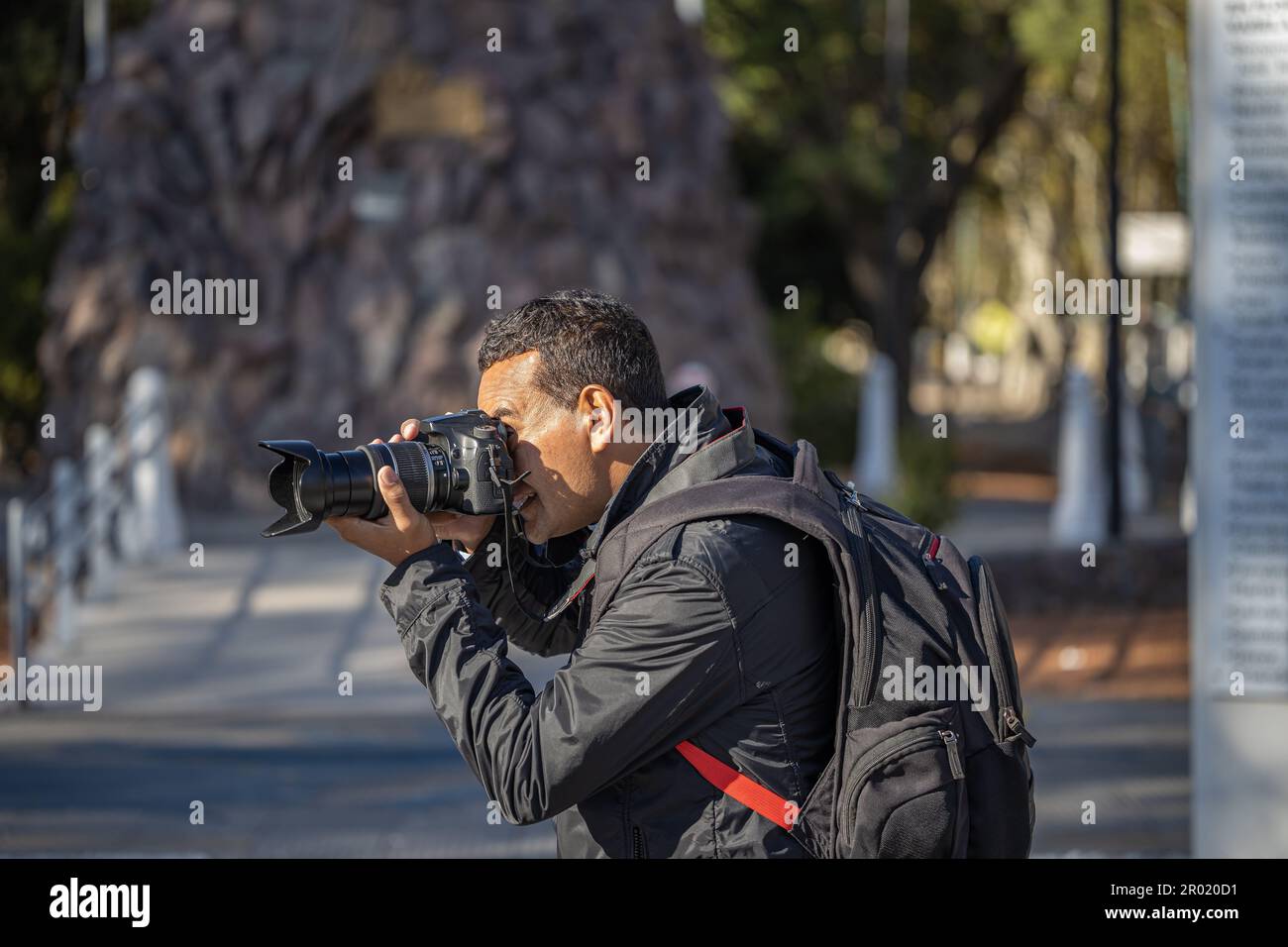 Il fotografo latino scattando una foto con la sua macchina fotografica. Foto Stock