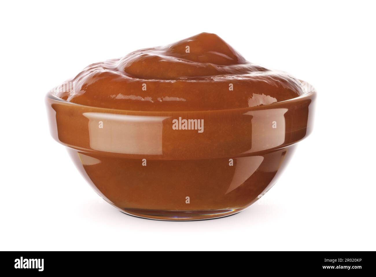 Salsa al caramello nella ciotola di vetro isolata su fondo bianco. Foto Stock