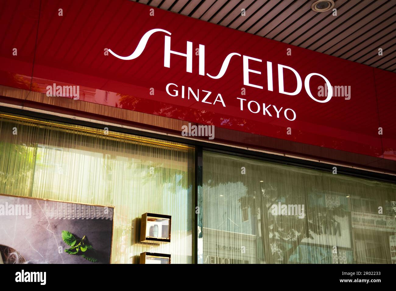 Ho Chi Minh City, Vietnam - 1 maggio 2023: Cartello commerciale del negozio di cosmetici con logo Shiseido rosso e bianco. Pubblicità di marca famosa sopra un deposito Foto Stock