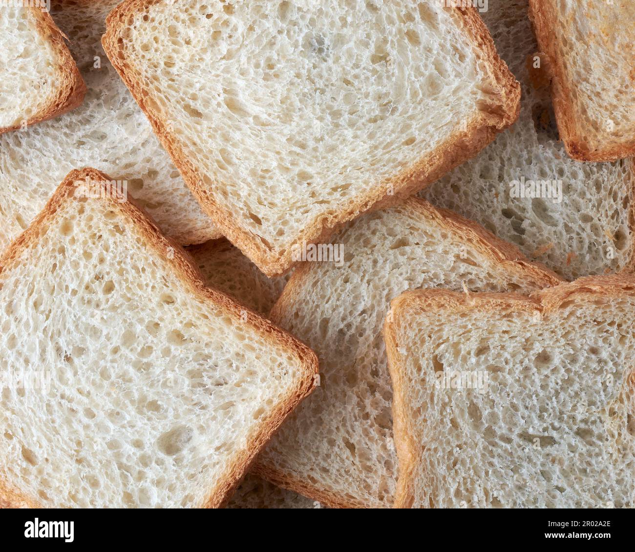 fetta di pane bianco a cornice intera, cibo popolare in molte culture e utilizzato per preparare panini, toast e altri piatti, di colore più chiaro Foto Stock
