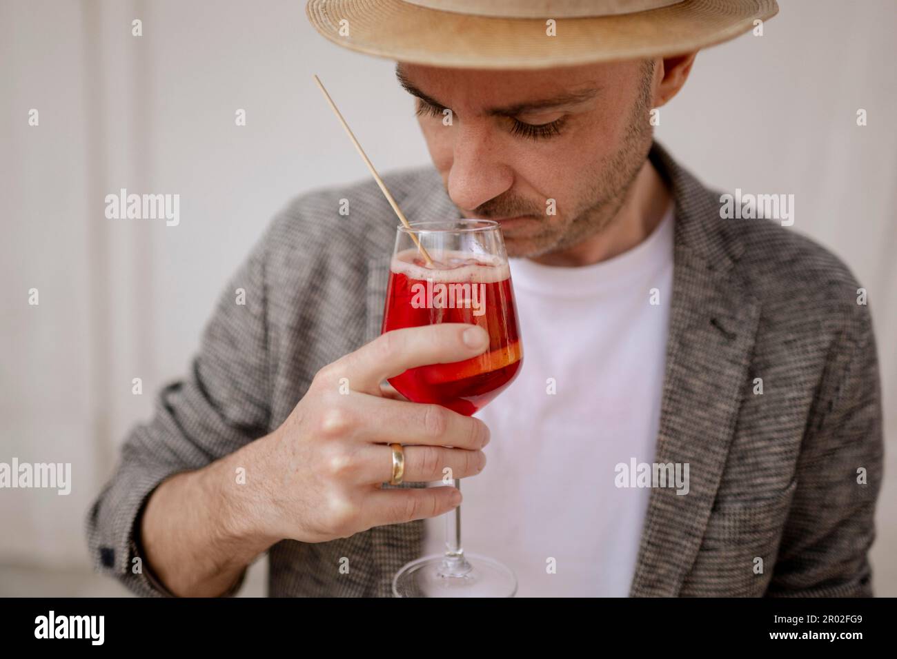 Uomo con un cappello e un bicchiere di Aperol Spritz Foto Stock