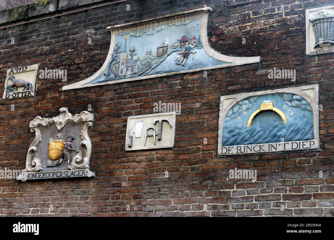 Vecchie scuderie su un muro che mostrano i mestieri e le occupazioni degli abitanti di casa ad Amsterdam, Olanda, Paesi Bassi. Foto Stock