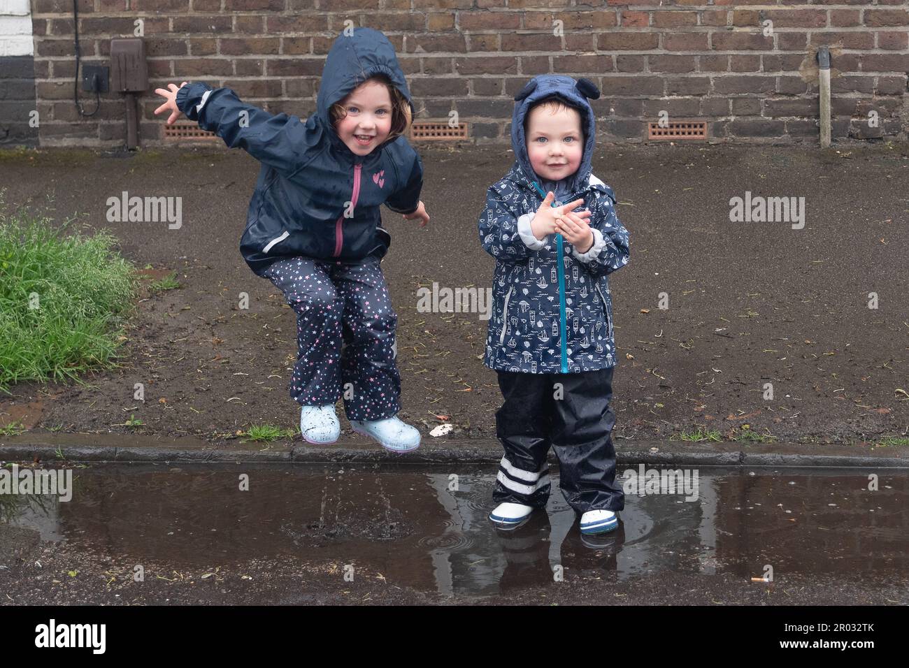 Windsor, Berkshire, Regno Unito. 6th maggio, 2023. Divertimento nelle pozzanghere per due cucciolate al Bexley Street Coronation party. Credit: Maureen McLean/Alamy Live News Foto Stock