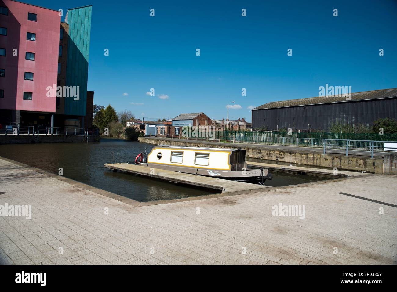 Barca stretta e il bacino del canale di Loughborough sul Canal Grand Union, Loughborough, Leicestershire, Inghilterra, Regno Unito, trascurato dai moderni appartamenti per studenti. Foto Stock