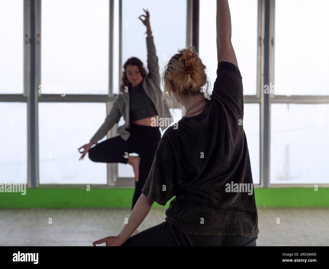 Lezione di yoga, giovane insegnante di yoga e studentessa pratica la loro routine quotidiana mattutina. Foto Stock