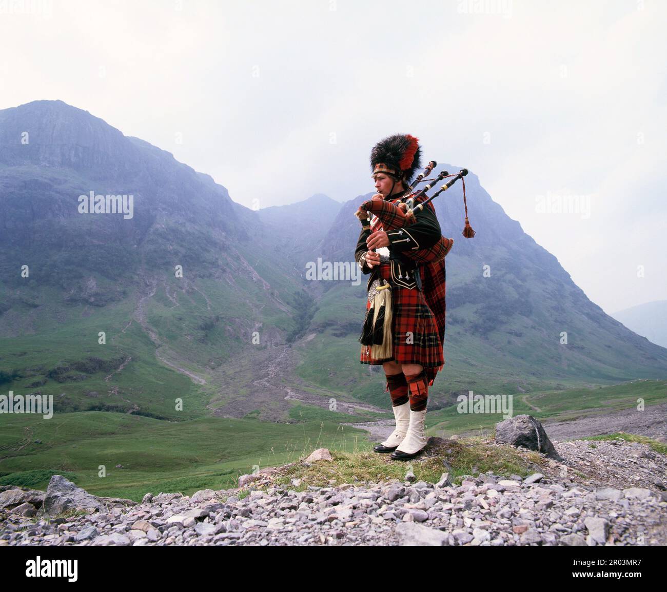 Scozia. Highlands. Piper scozzese nel paesaggio. Foto Stock