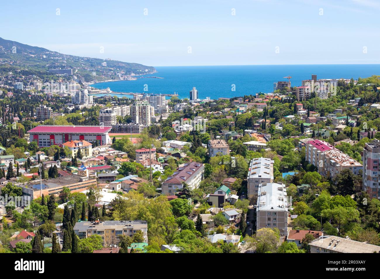 mare. Mare blu e montagne, ai piedi della città resort con case alte e alberghi. Foto Stock