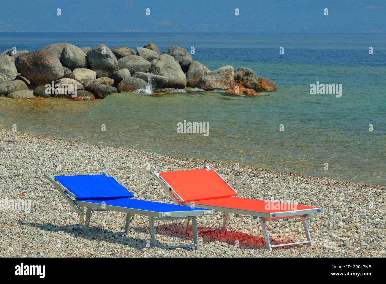 Lettini da spiaggia in rosso e blu a Maderno sul Lago di Garda in Italia. Foto Stock