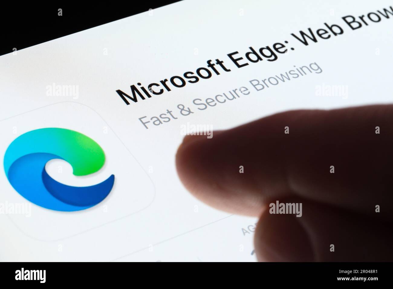 App Microsoft Edge visualizzata in App Store sullo schermo dell'ipad e con un dito sfocato che punta verso di essa. Messa a fuoco selettiva. Stafford, Regno Unito, 6 maggio 2023 Foto Stock