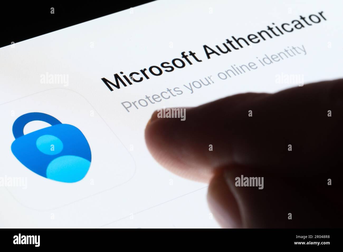 App Microsoft Authenticator visualizzata in App Store sullo schermo dell'ipad e con un dito sfocato rivolto verso di essa. Messa a fuoco selettiva. Stafford, Regno Unito, maggio Foto Stock