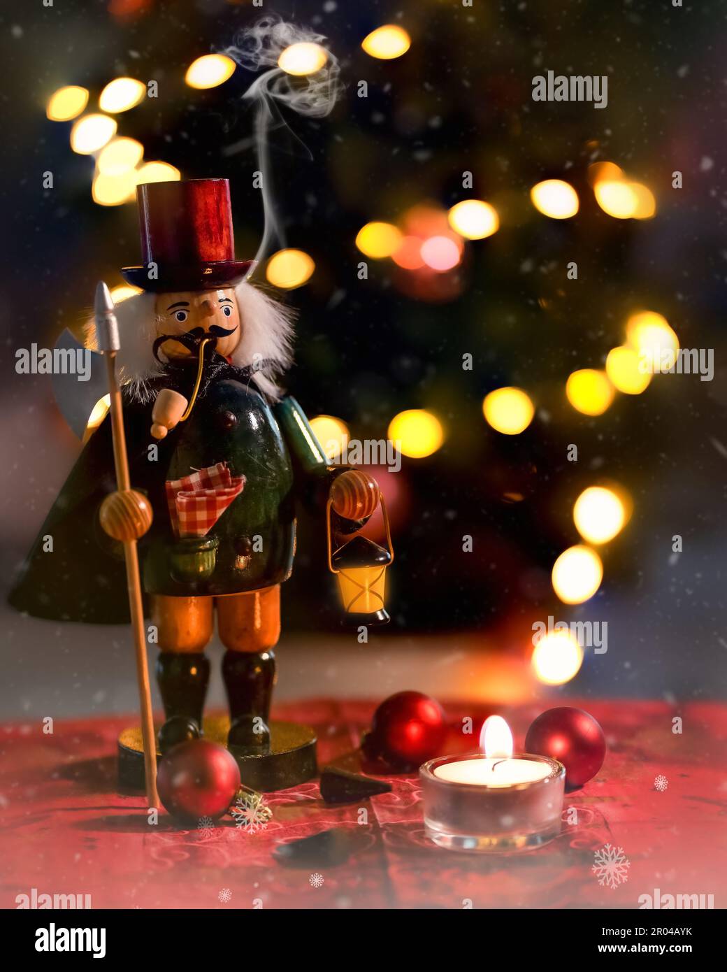 Un colpo verticale di un nutcracker vicino ad una candela che brucia su uno sfondo di Natale Foto Stock