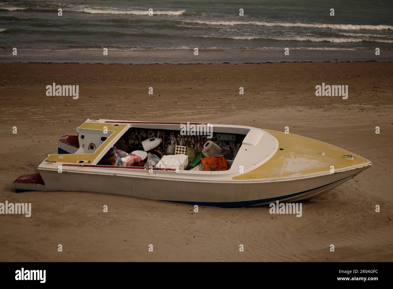 Barca piena di rifiuti - lettiera spiaggia Foto Stock