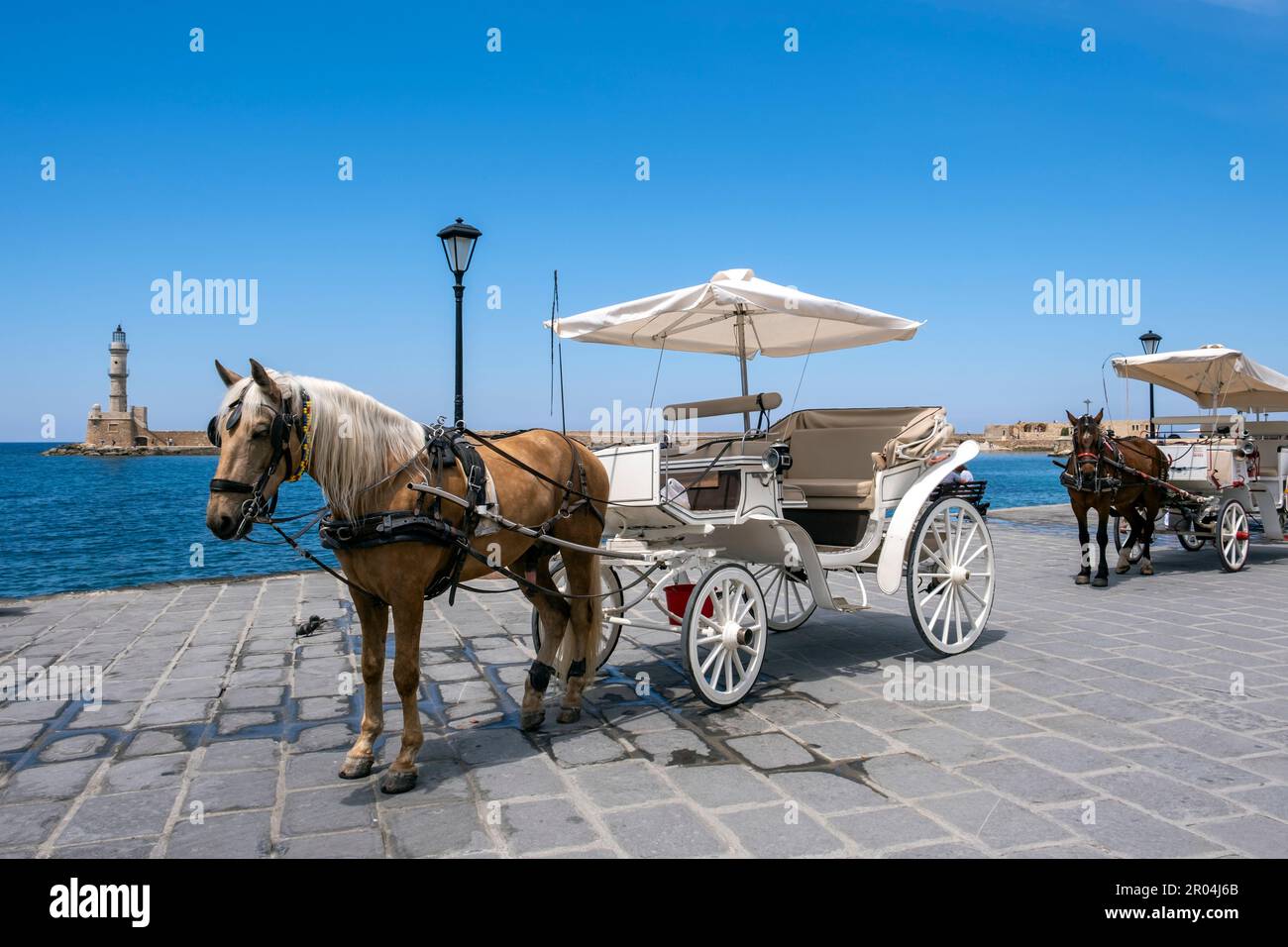 Cavalli e carrozze nel vecchio porto veneziano di la Canea, Creta, Grecia. Foto Stock