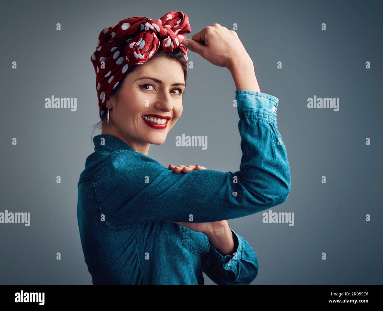 Im una donna forte e indipendente. Studio ritratto di una giovane donna attraente flexing il suo bicep mentre in piedi su uno sfondo grigio. Foto Stock