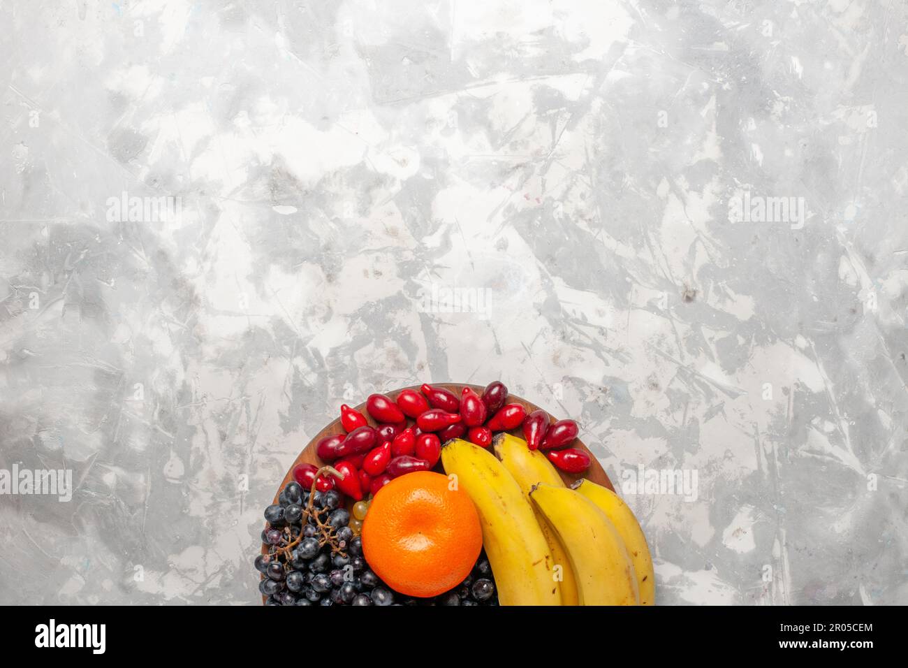 vista dall'alto frutta fresca composizione banane dogwoods e uva su banco  bianco frutta fresca bacche vitamina Foto stock - Alamy