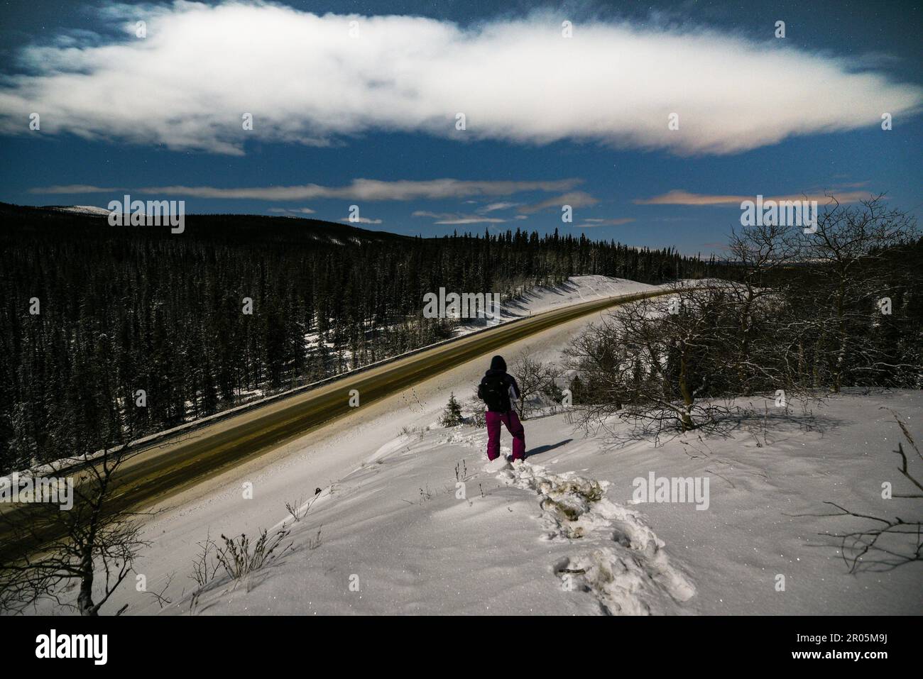 Notte tempo nuvoloso vista nel nord del Canada durante la stagione invernale su una notte blu brillante, stellato con un escursionista, persona in vista. Foto Stock