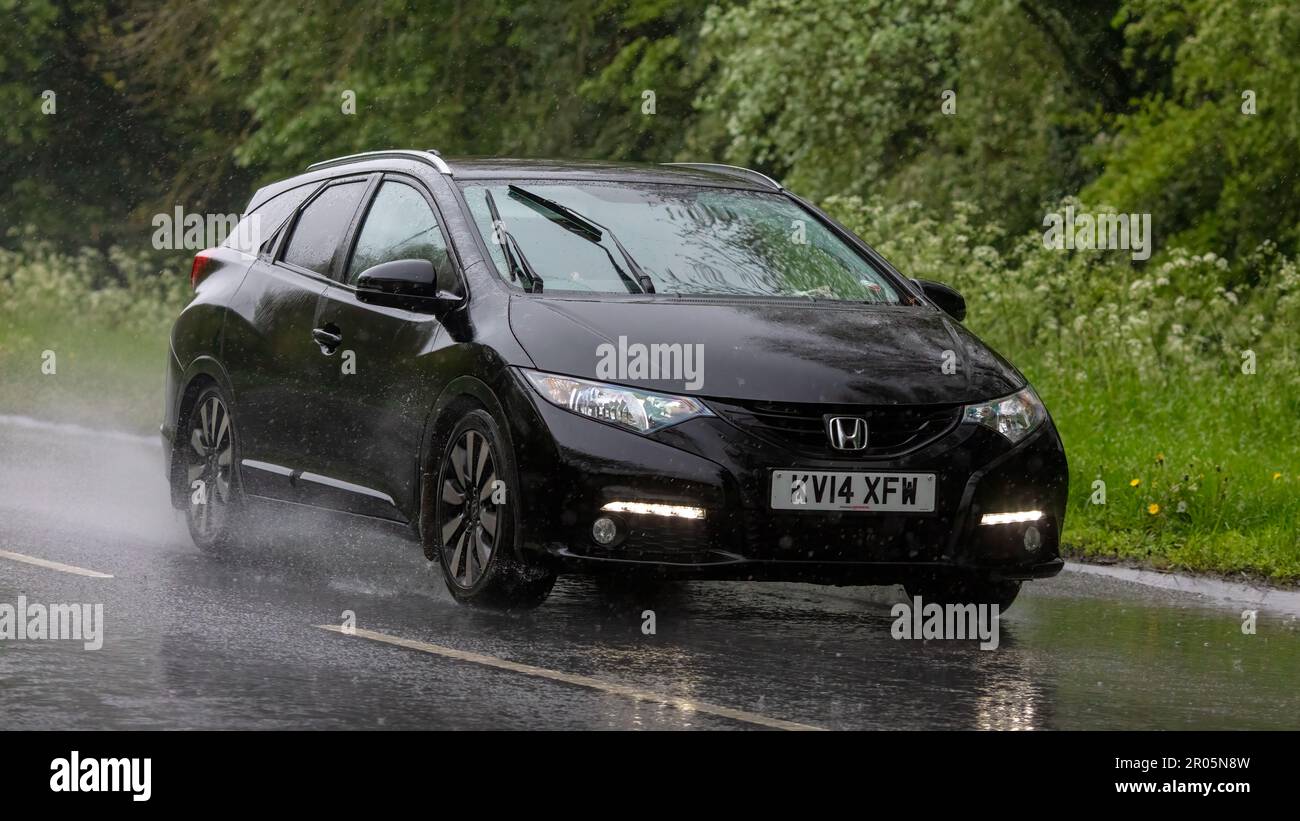 Stony Stratford, Bucks, Regno Unito - Maggio 6th 2023. Honda CIVIC 2014 nero guida sotto la pioggia su una strada bagnata Foto Stock