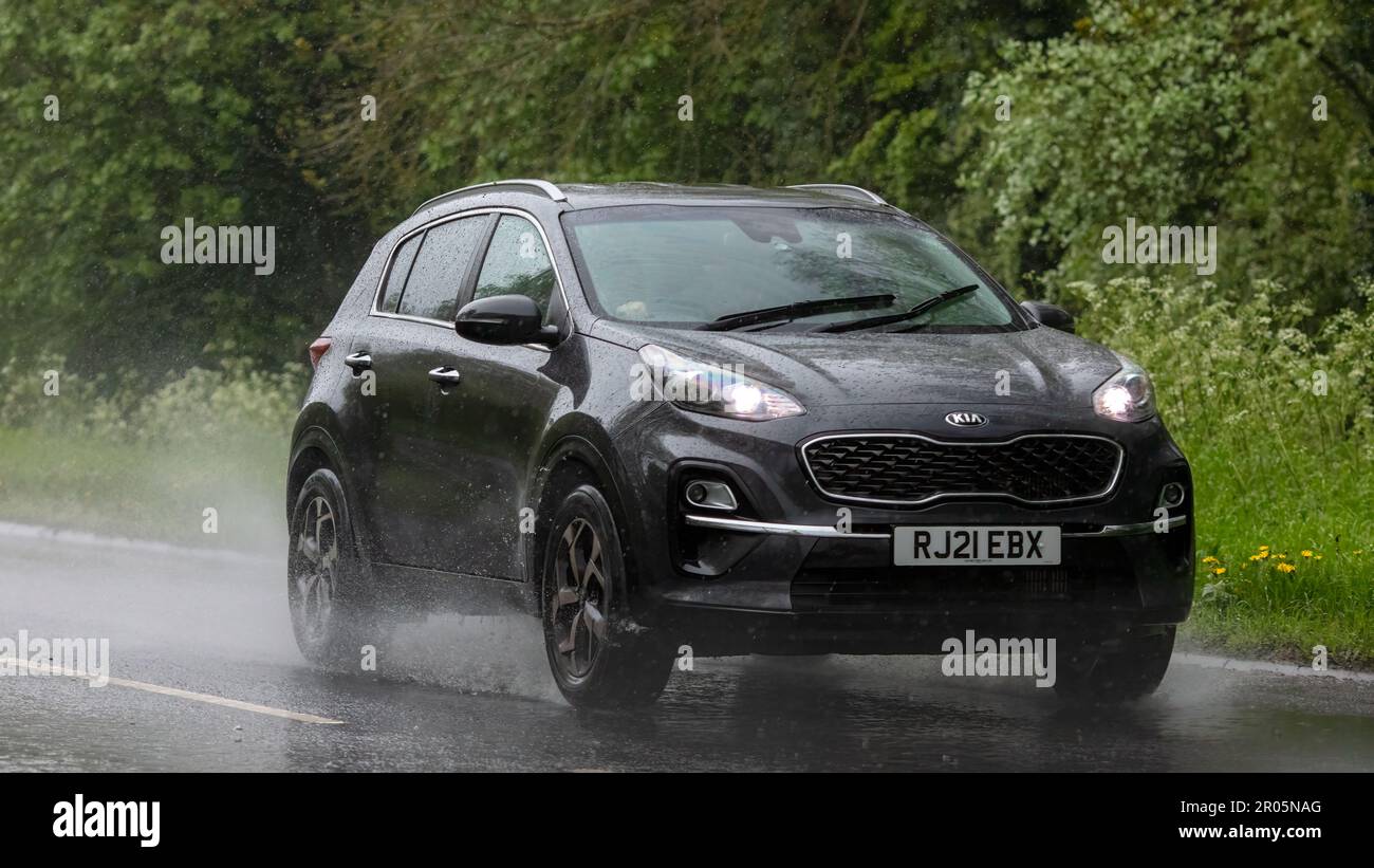 Stony Stratford, Bucks, Regno Unito - Maggio 6th 2023. 2021 elettrico ibrido KIA SPORTAGE guidare sotto la pioggia su una strada bagnata Foto Stock