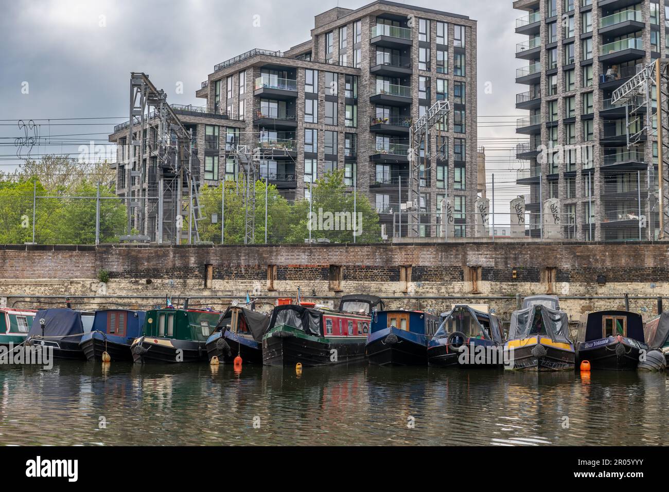 Londra. UK- 05.04.2023. Una vista del Bacino di St Pancras con chiatte ormeggiate sul canale e blocchi residenziali di appartamenti sullo sfondo. Foto Stock