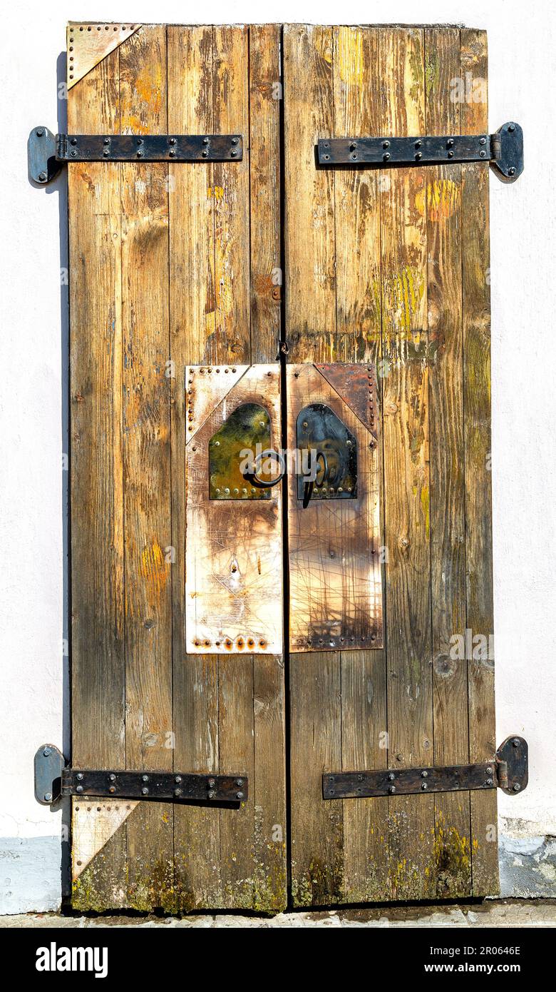 Chiuso vecchio cancello di legno intemperiato con cerniere in metallo forgiato della chiesa antica Foto Stock