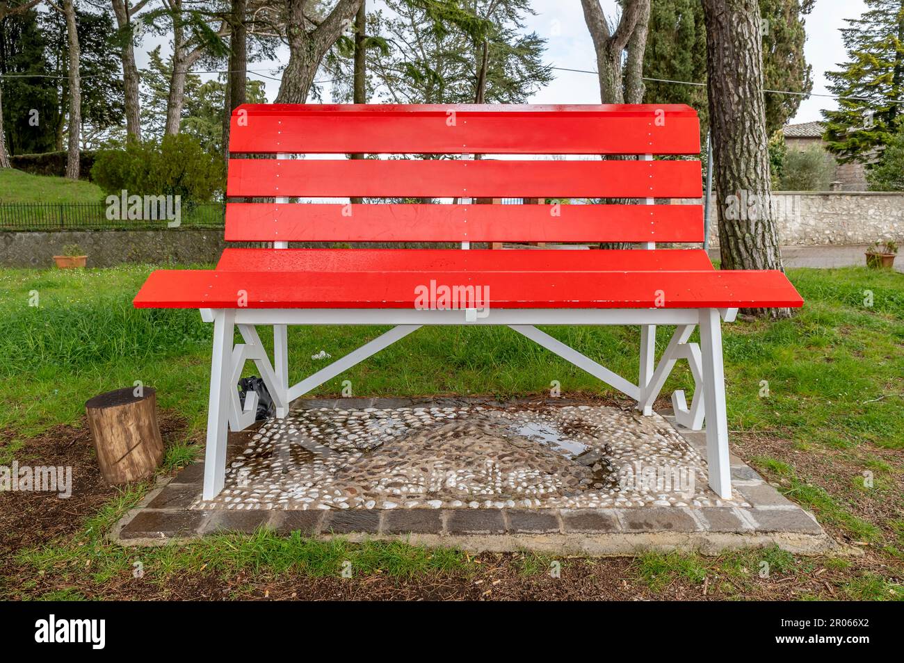 Una gigantesca panchina di legno rosso in un parco cittadino a Montefiascone, Italia Foto Stock