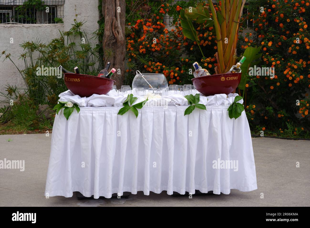 Bevande sul tavolo con lenzuola bianche all'aperto per la preparazione della festa Foto Stock