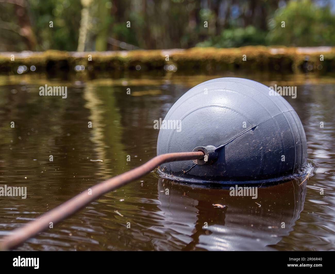 Fotografia ravvicinata di una vecchia valvola a galleggiante del serbatoio dell'acqua con un'asta arrugginita in un tubo di plastica che perde, in un serbatoio rustico in un campo vicino alla città di Foto Stock