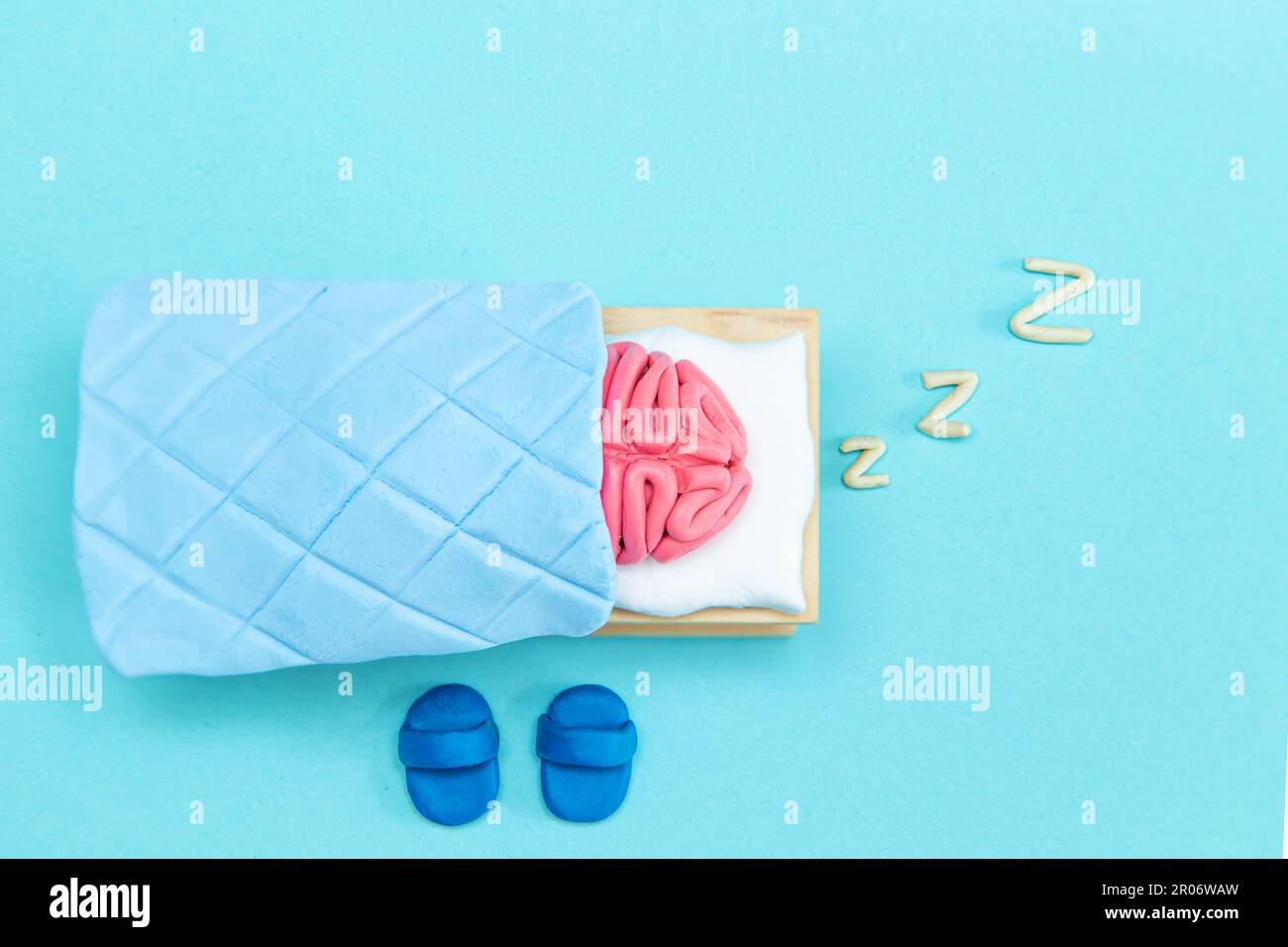 Il cervello umano rosa della plastilina sta dormendo. Concetto di riposo mentale. Sfondo blu. Foto Stock