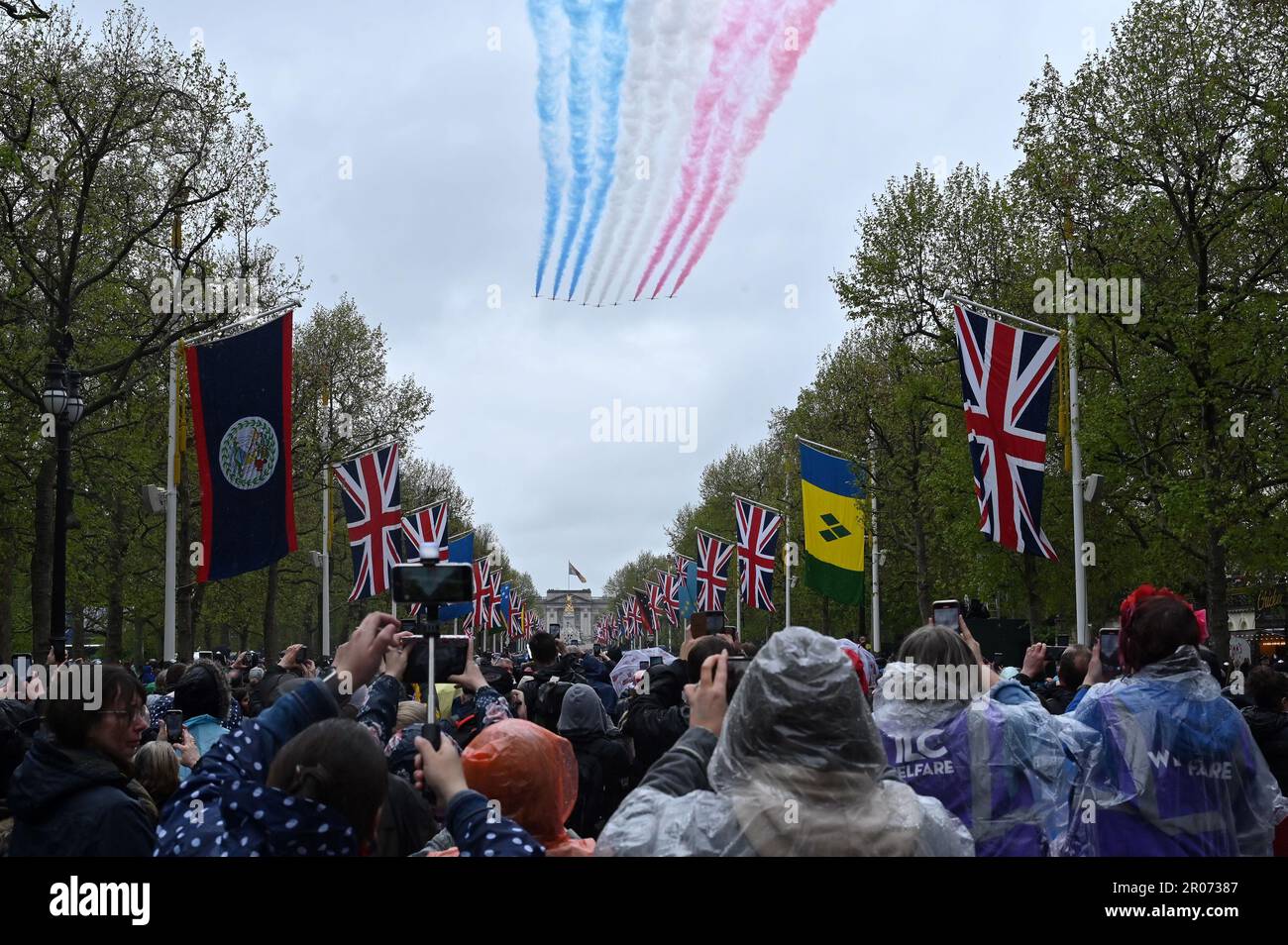 Le folle osservano le frecce rosse che prendono parte al volo mentre sorvolano il Mall dopo l'incoronazione di Re Carlo III e della Regina Camilla a Londra. Data immagine: Sabato 6 maggio 2023. Foto Stock