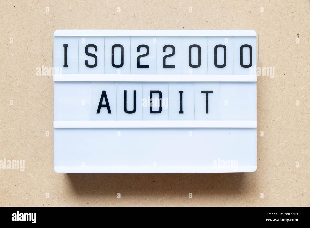 Lightbox con parola ISO 22000 audit su sfondo legno Foto Stock