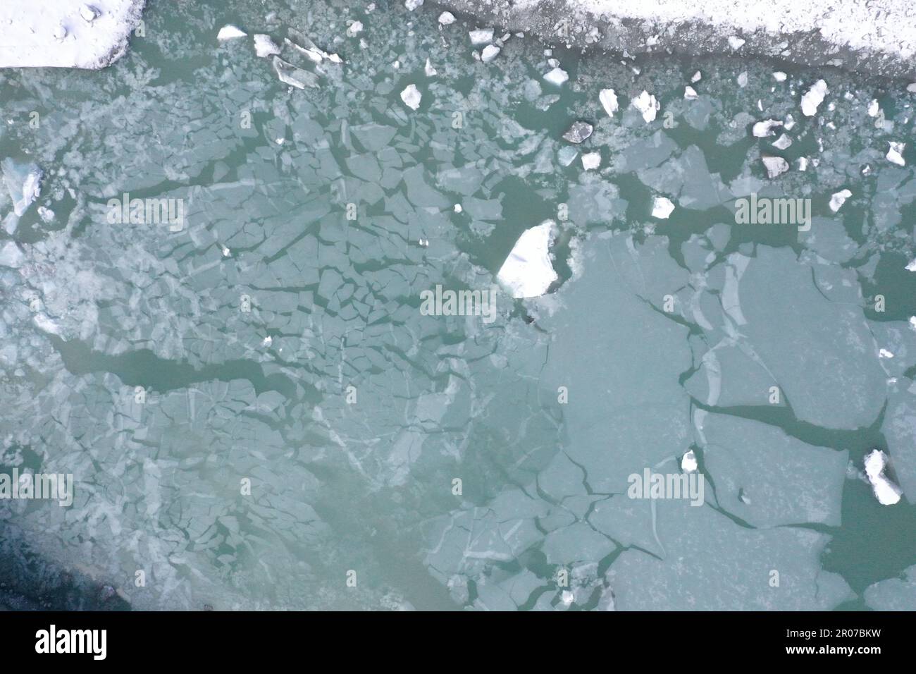 Vista aerea del ghiacciaio con acqua ghiacciata, crepacci circolari e orizzontali e neve - Alpe Italiana Foto Stock