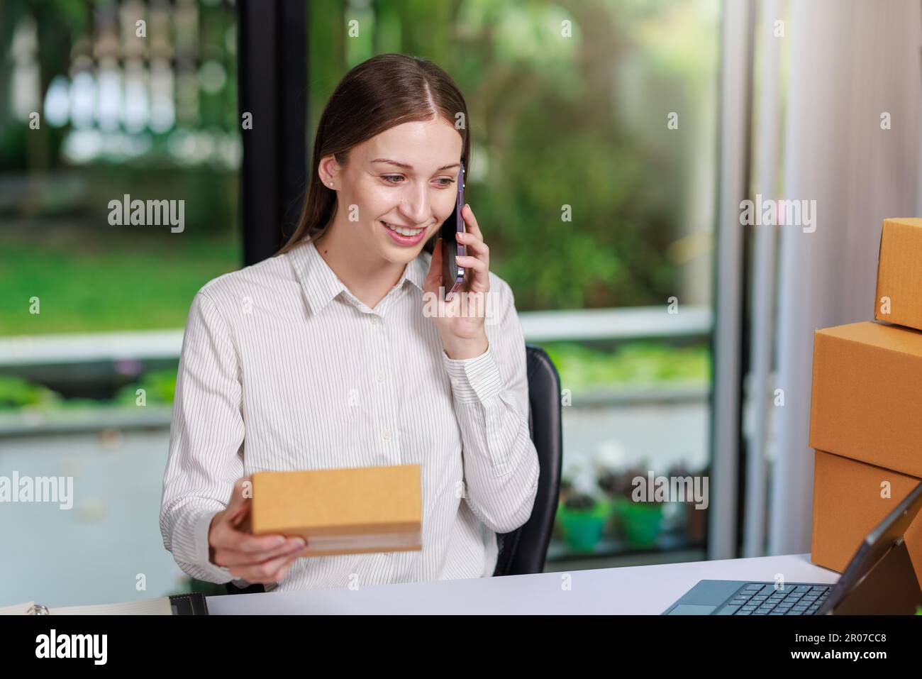 Concetto di consegna e vendita dei pacchi online,concessionario che utilizza un calcolatore per calcolare le vendite per la giornata in un negozio online per il pacco b Foto Stock