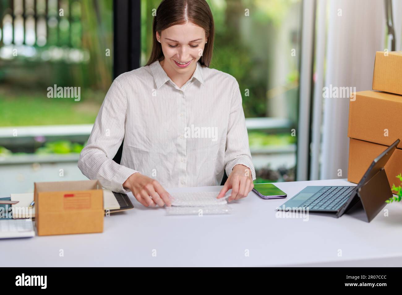 Concetto di consegna e vendita dei pacchi online,concessionario che utilizza un calcolatore per calcolare le vendite per la giornata in un negozio online per il pacco b Foto Stock