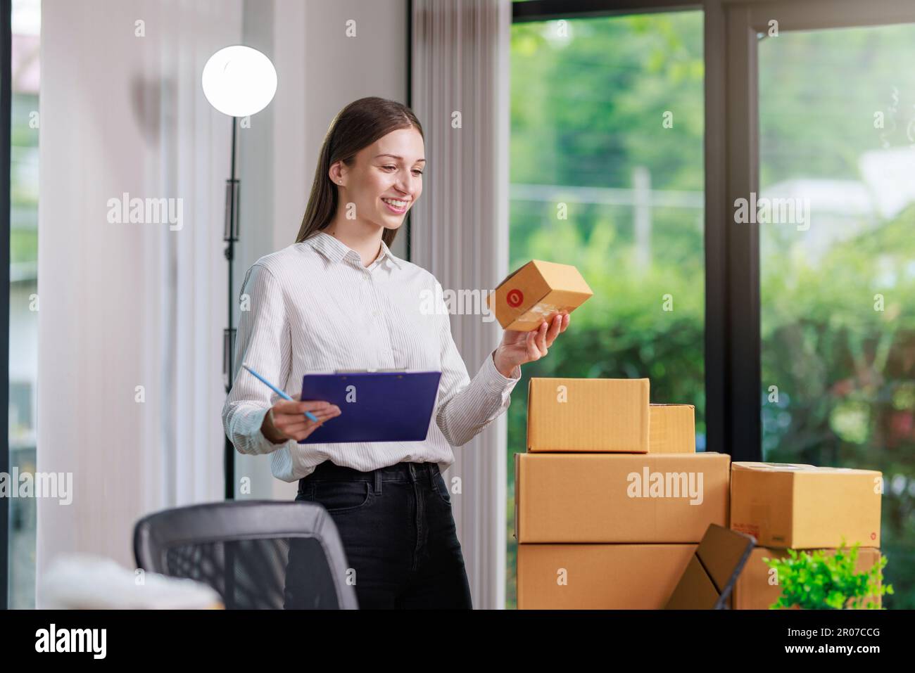 Concetto di consegna e vendita dei pacchi online,concessionario che utilizza un calcolatore per calcolare le vendite per la giornata in un negozio online per il pacco b Foto Stock