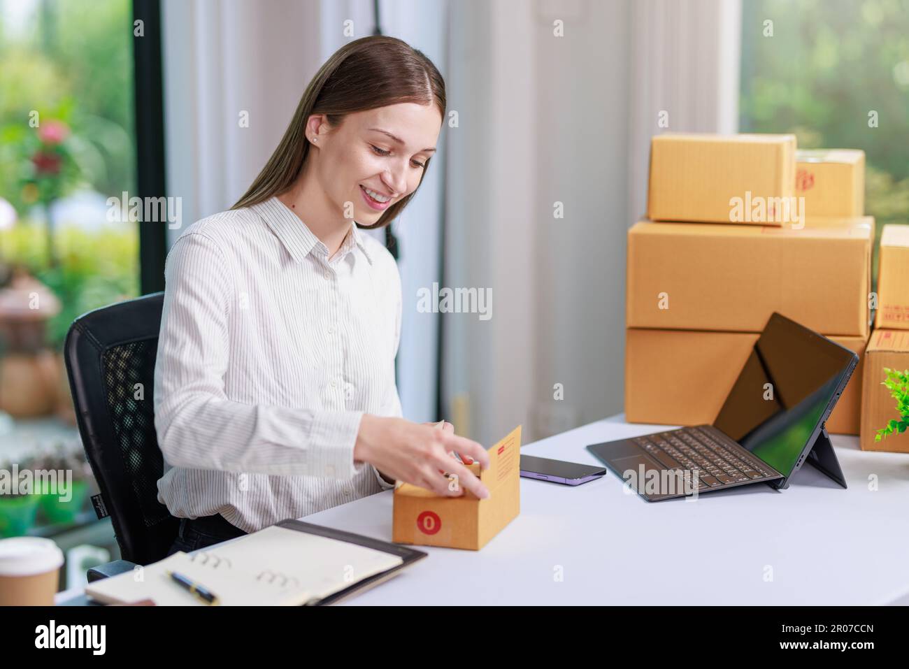 Concetto di consegna e vendita dei pacchi online,concessionario che utilizza un calcolatore per calcolare le vendite per la giornata in un negozio online per il pacco b Foto Stock