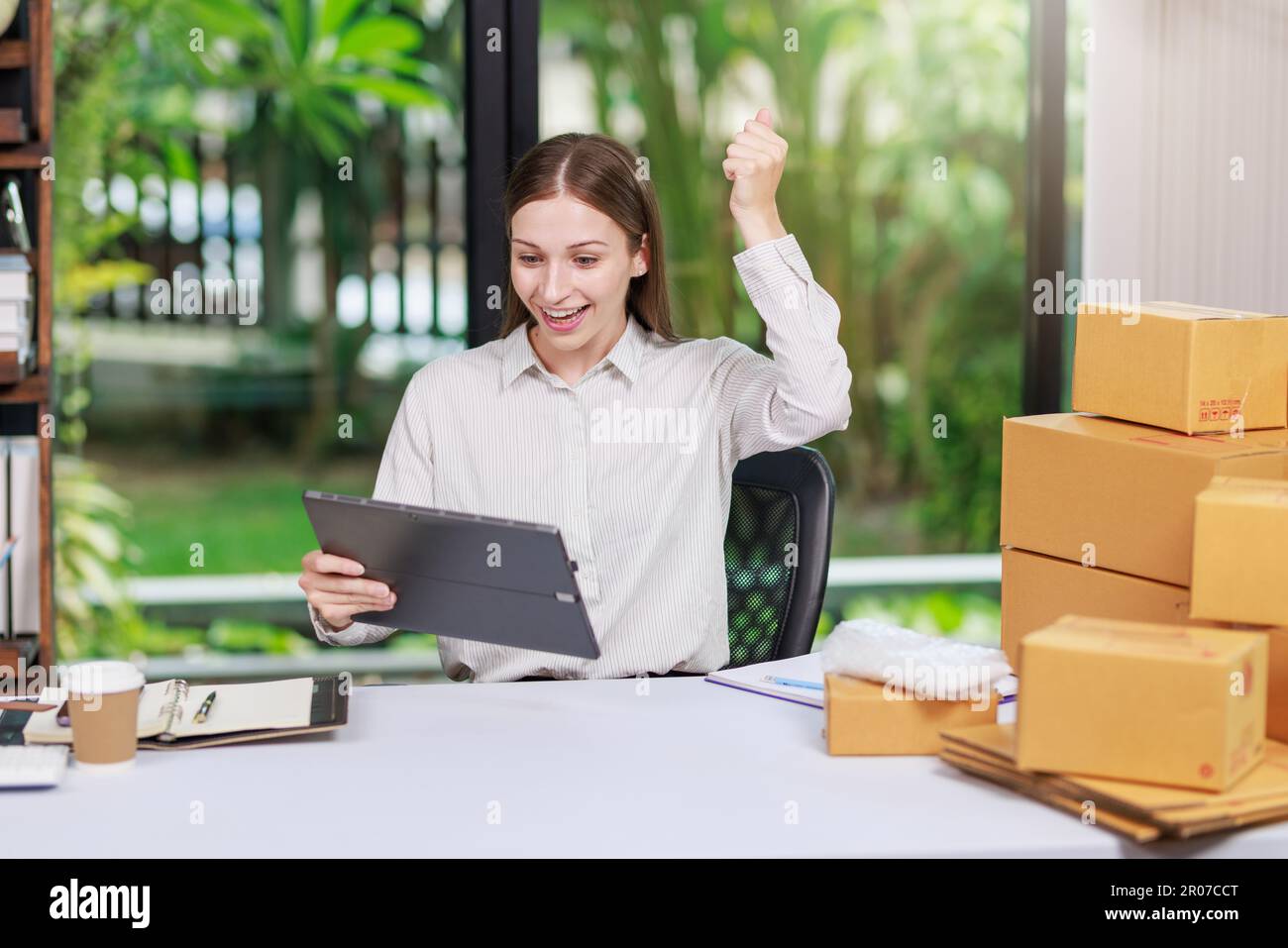 Concetto di consegna e vendita dei pacchi online,concessionario che utilizza un calcolatore per calcolare le vendite per la giornata in un negozio online per il pacco b Foto Stock