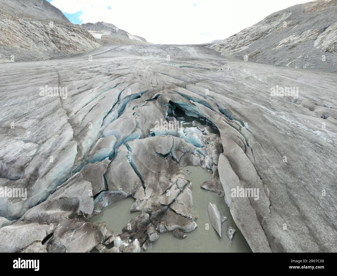 Vista aerea del ghiacciaio con acqua ghiacciata, crepacci circolari e orizzontali e neve - Alpe Italiana Foto Stock