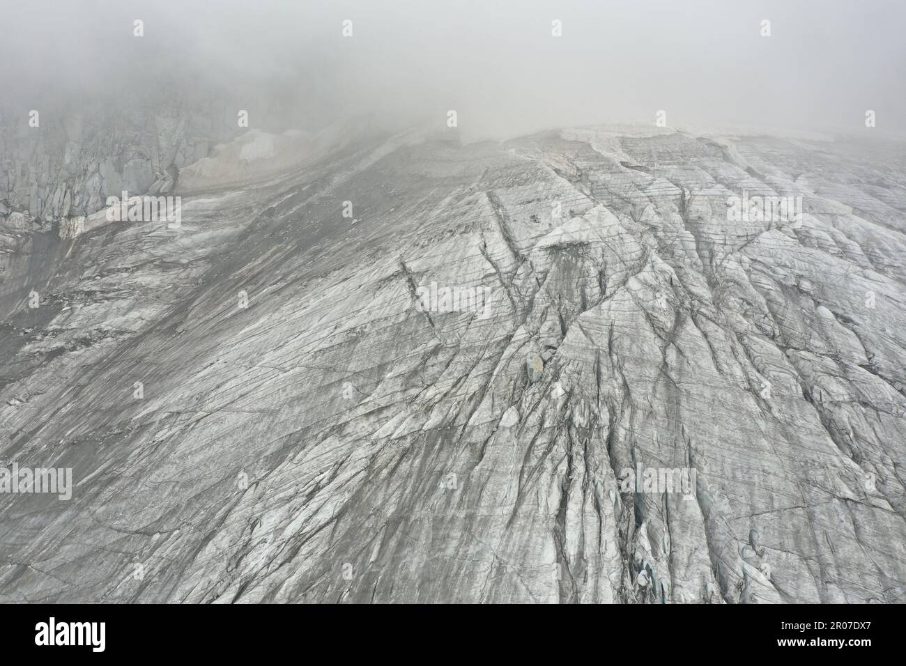 Vista aerea del ghiacciaio con acqua ghiacciata, crepacci circolari e orizzontali e neve - Alpe Italiana Foto Stock