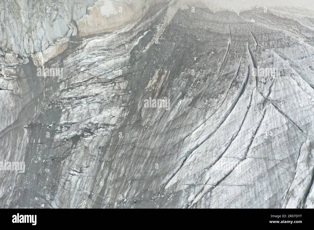 Vista aerea del ghiacciaio con acqua ghiacciata, crepacci circolari e orizzontali e neve - Alpe Italiana Foto Stock