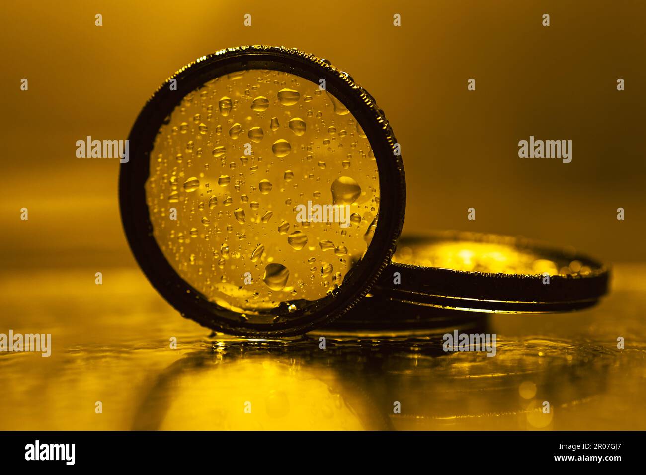 l'obiettivo filtra con gocce d'acqua riflesse nello specchio Foto Stock