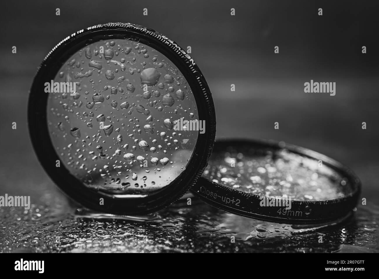 l'obiettivo filtra con gocce d'acqua riflesse nello specchio Foto Stock