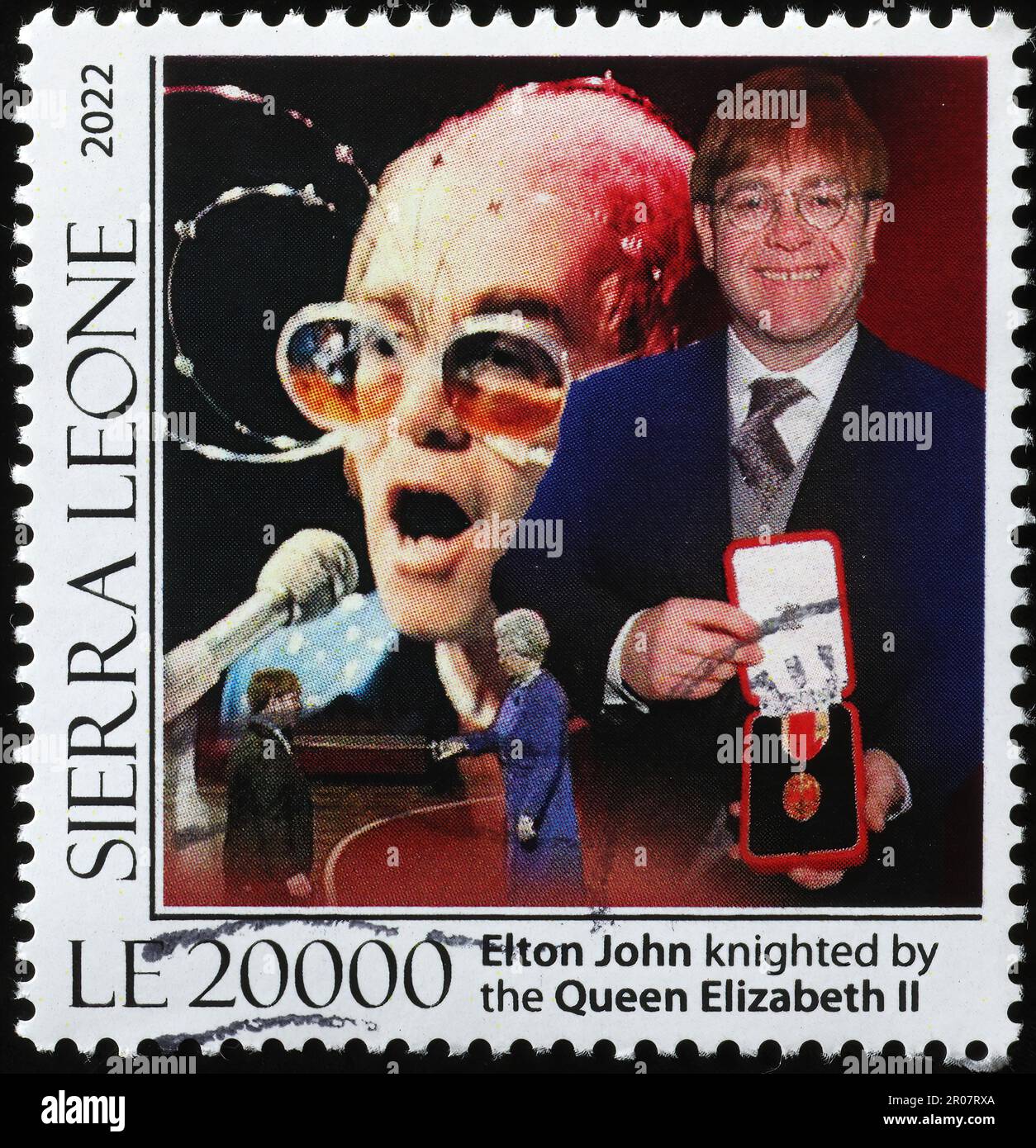 Elton John inginocchiato dalla regina sul francobollo Foto Stock