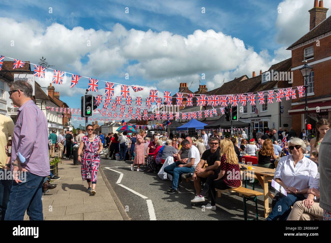 7th maggio 2023. Odiham, Hampshire, Inghilterra, Regno Unito. Il lungo fine settimana di festa per l'incoronazione di re Carlo III e la regina Camilla continuò con una grande festa di strada lungo la High Street villaggio, che è stato decorato con concia rosso bianco e blu. È stato un pomeriggio di sole per l'evento popolare, che ha attirato molte persone a celebrare l'occasione reale. Foto Stock