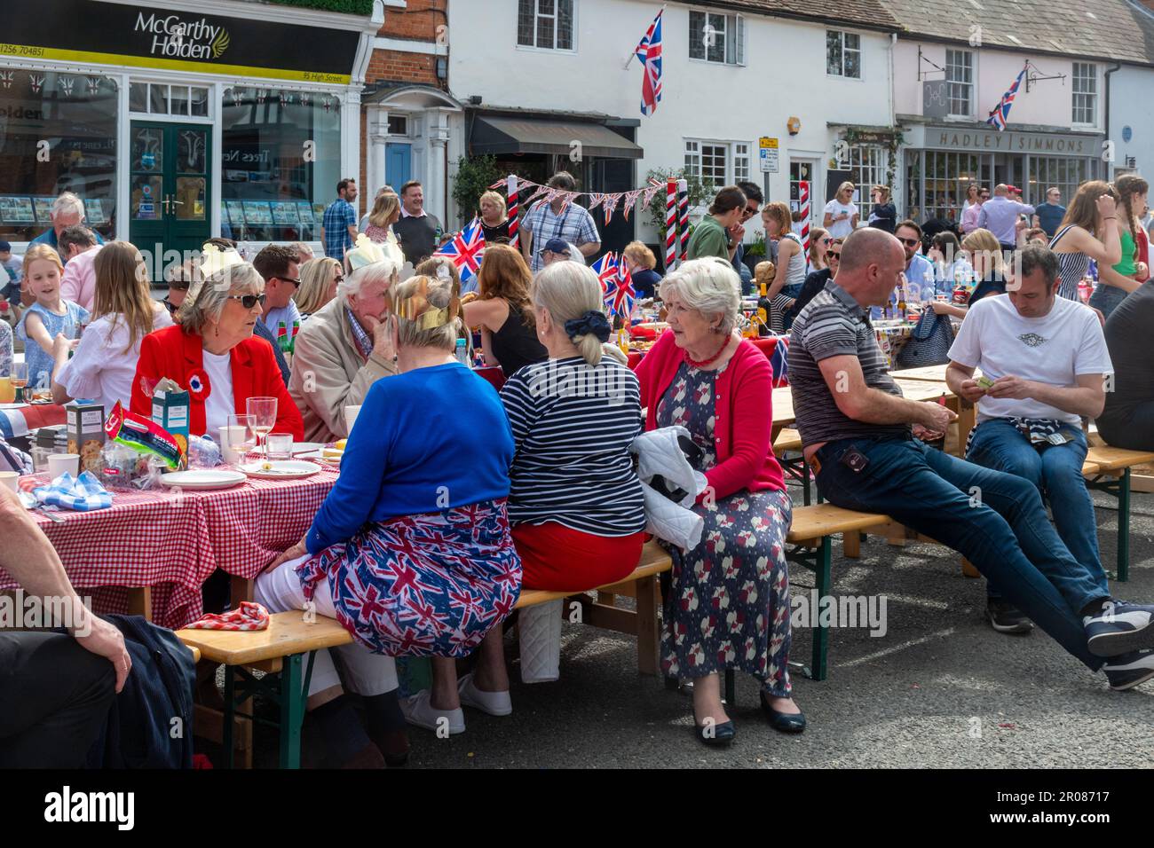 7th maggio 2023. Odiham, Hampshire, Inghilterra, Regno Unito. Il lungo fine settimana di festa per l'incoronazione di re Carlo III e la regina Camilla continuò con una grande festa di strada lungo la High Street villaggio, che è stato decorato con concia rosso bianco e blu. È stato un pomeriggio di sole per l'evento popolare, che ha attirato molte persone a celebrare l'occasione reale. Foto Stock