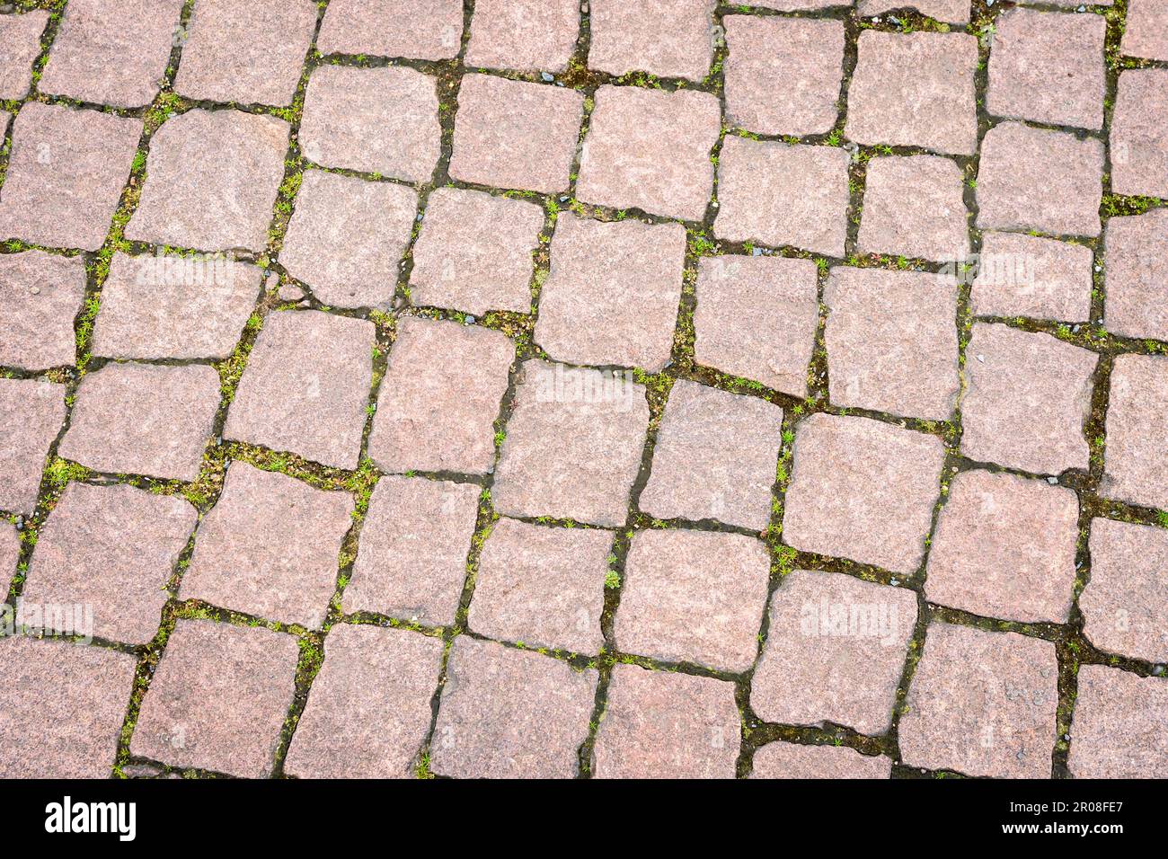 La strada è lastricata di pietra decorativa. La vecchia strada di pietre di pavimentazione di granito. Foto Stock
